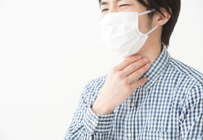 喉を抑える男性